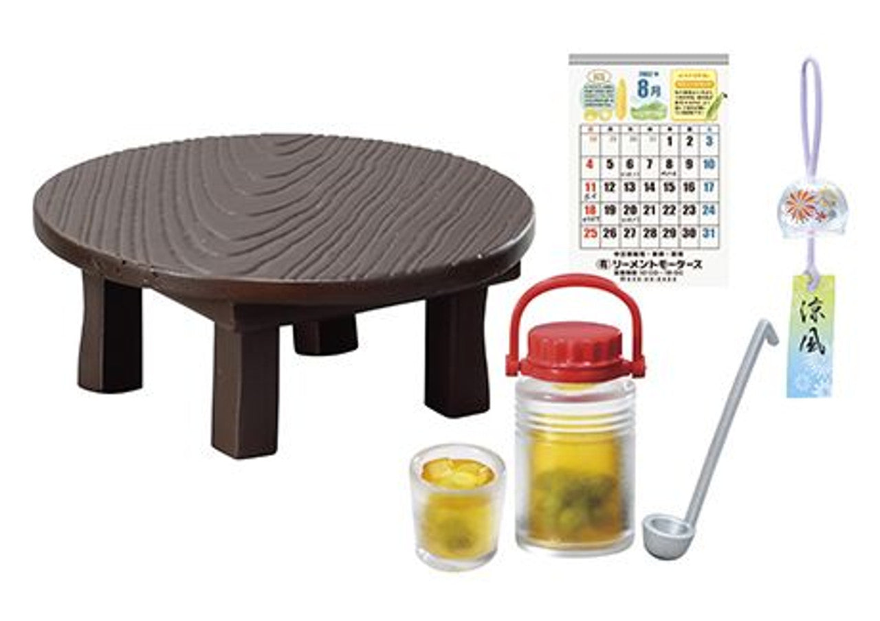Round brown table with a red Japanese-style tea set and a calendar on a white background