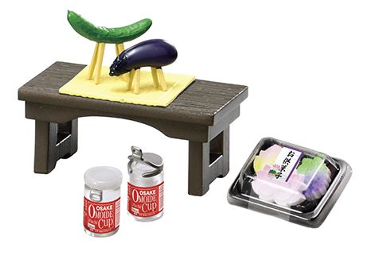 Miniature table set with food items and condiments on a white background