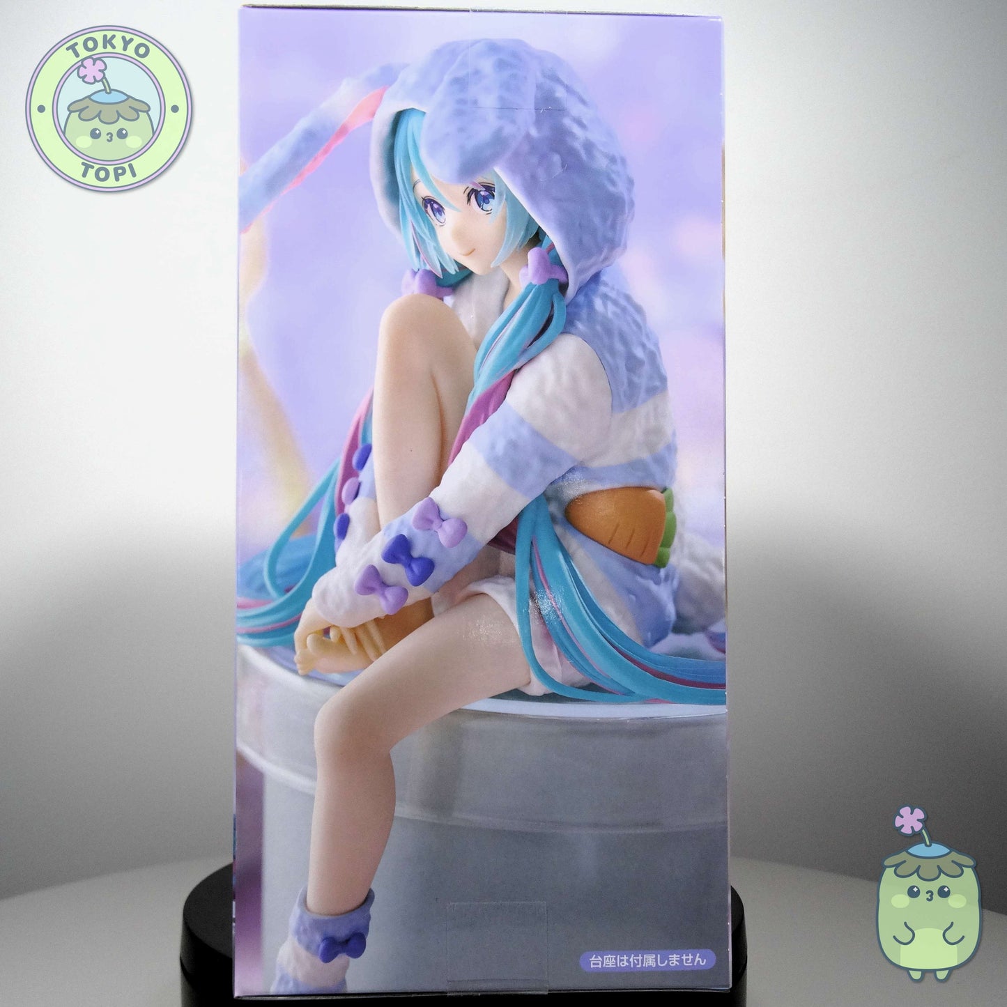 This officially licensed FuRyu figure captures Miku in charming bunny-eared pajamas, complete with a plush hooded design. Standing approximately 14 cm tall, the Noodle Stopper is engineered to perch securely on shelves, desks, or display edges, making it an ideal piece for expanding your Vocaloid collection vertically. The blue colourway and meticulous detailing showcase the character's signature aesthetic while maintaining the functional appeal collectors value in this figure format.
