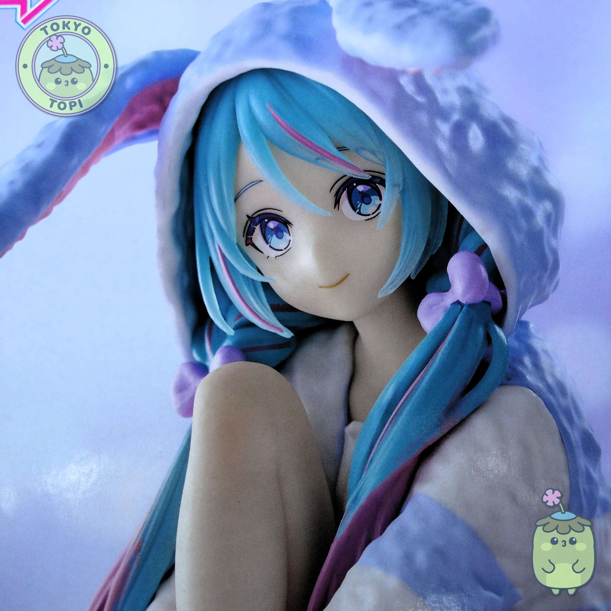 This officially licensed FuRyu figure captures Miku in charming bunny-eared pajamas, complete with a plush hooded design. Standing approximately 14 cm tall, the Noodle Stopper is engineered to perch securely on shelves, desks, or display edges, making it an ideal piece for expanding your Vocaloid collection vertically. The blue colourway and meticulous detailing showcase the character's signature aesthetic while maintaining the functional appeal collectors value in this figure format.