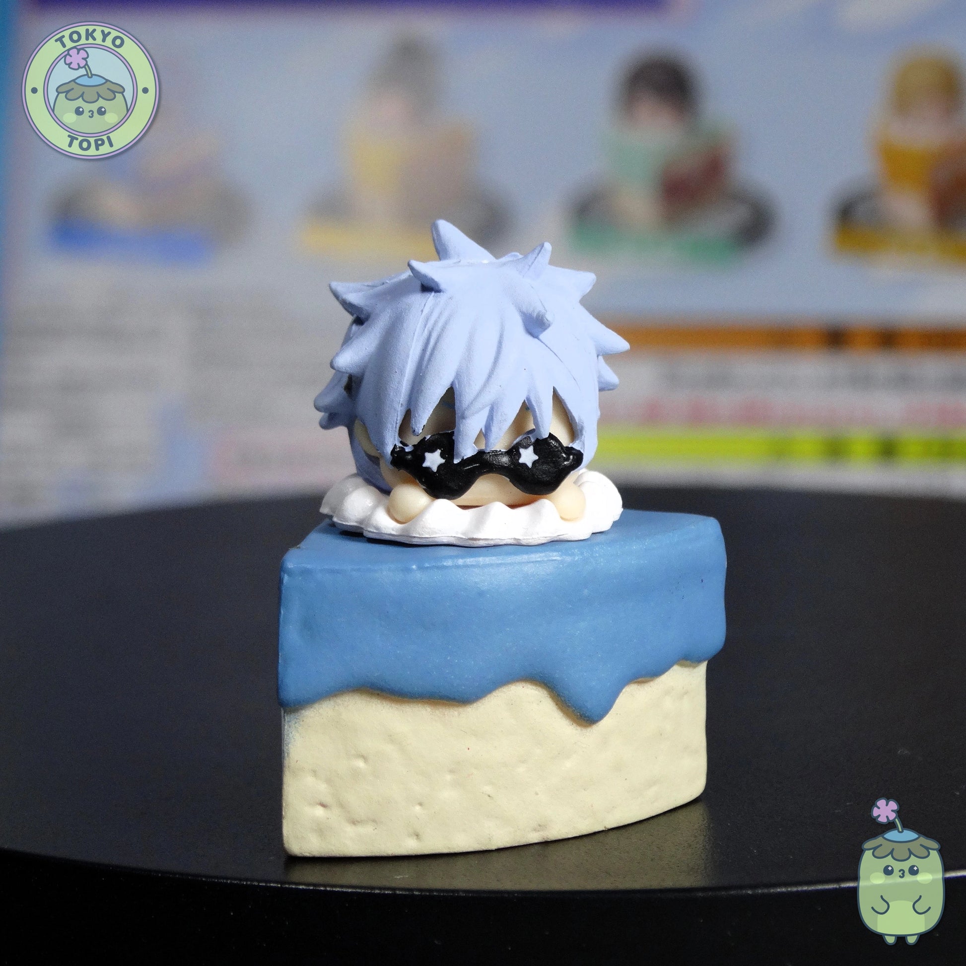 Satoru Gojo Version!

Five beloved characters perch adorably atop their own cake slices—Satoru Gojo, Suguru Geto, Shoko Ieiri, Kento Nanami, and Toji Fushiguro. The best part? Each character's head spins around, letting you pose them however you fancy.

Every figure nestles safely in its own capsule, and you'll get a handy information sheet to complete your collection. Perfect for JJK fans who want their favourite characters displayed with a sweet twist!