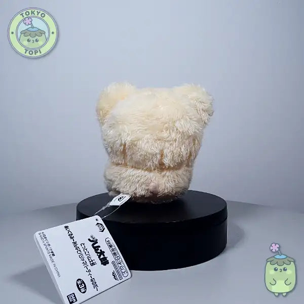 Plush hamster toy with cartoon face in a little bowtie and tiny little hands and feet.